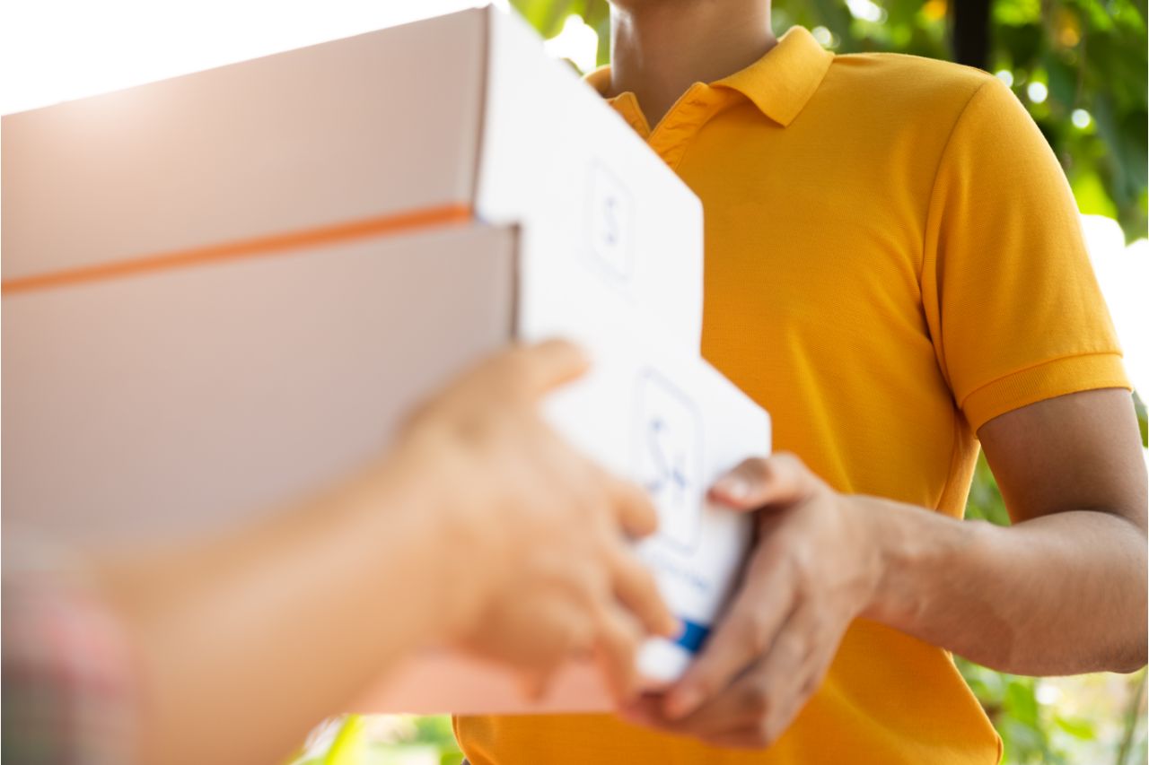 A man with a polo shirt delivering a package