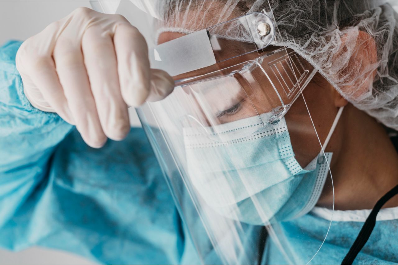 Medical worker wearing a face mask, face shield, and coveralls